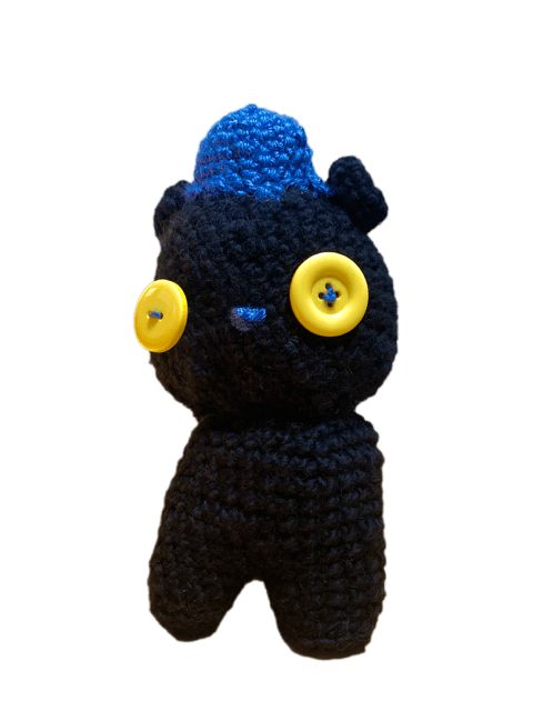 Black crochet bear plush with blue hat and yellow button eyes